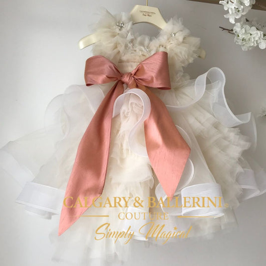 ⭐⭐⭐⭐⭐ 1,500+ Reviews. Order 2026 Christening Outfits. Shop no-itch, no exposed seams & master-tailored couture. Buy 21 years of artisan excellence. Shop now. White dress with a large pink bow on a hanger, branded 'Calgary & Ballerini Couture'.