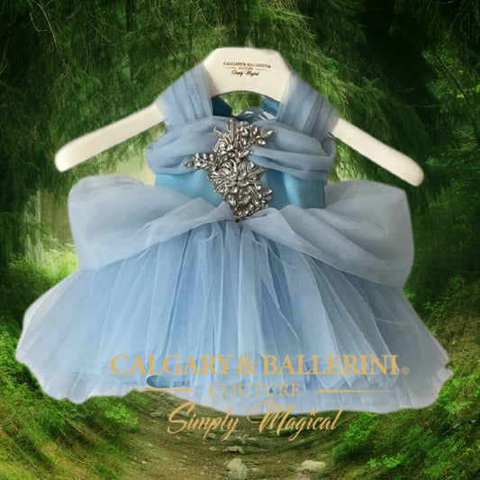Buy disney princess dresses for girls Light blue dress with a large bow on a hanger against a green natural background
