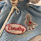 Order bespoke blue gingham Dorothy first birthday matching dresses, artisan handcrafted with storybook character embroidery for luxury celebrations.