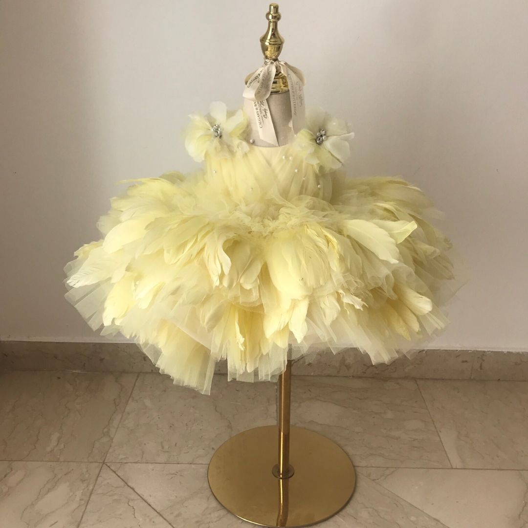 Buy this high-end yellow feather flower girl dress and first birthday dress, artisan handcrafted with a puffy princess silhouette for exclusive events.