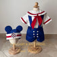 shop boys cruise outfits Children's sailor-themed outfit with matching headband on wooden mannequins, branded 'Calgary & Ballerini'.