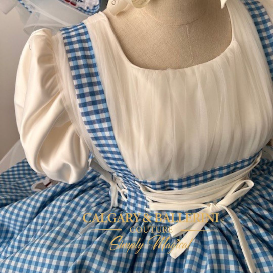 Shop our luxury mommy and me Dorothy gingham dress with detailed embroidery of the Tin Man and Lion, perfect for Wizard of Oz party ideas in 2026.