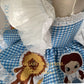 Where to order bespoke Dorothy Wizard of Oz first birthday outfit Calgary and Ballerini. Order a bespoke Dorothy Wizard of Oz first birthday dress, luxury artisan 3D character embroidery on blue gingham for showstopping party photos.