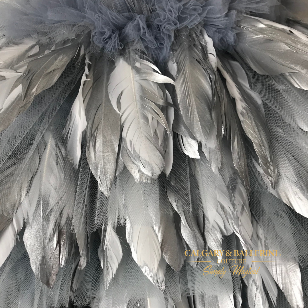 This custom couture silver snow feather dress is a wondrous confection of silver and white feathers, with metallic accents for added glamour.