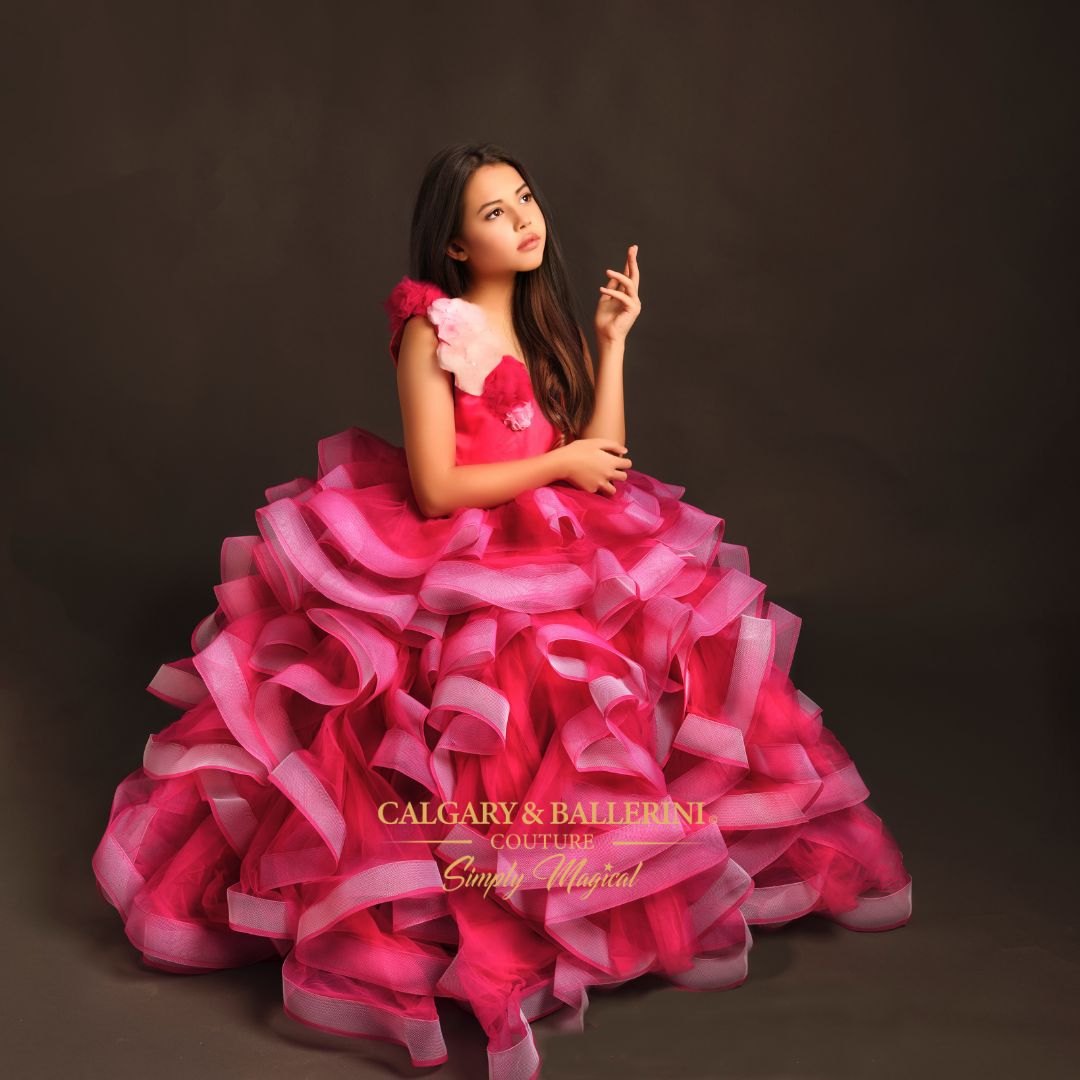 The pink Willow gown in Cherry Blossom is the perfect pageant dress or 10th birthday dress for your daughter. This luxurious flower girl dress is crafted with pink tulle and over 200 yards of horse hair braid for an ultra-luxe feel and volume. Handmade pink flowers and feathers run along the bodice in a chic design, while