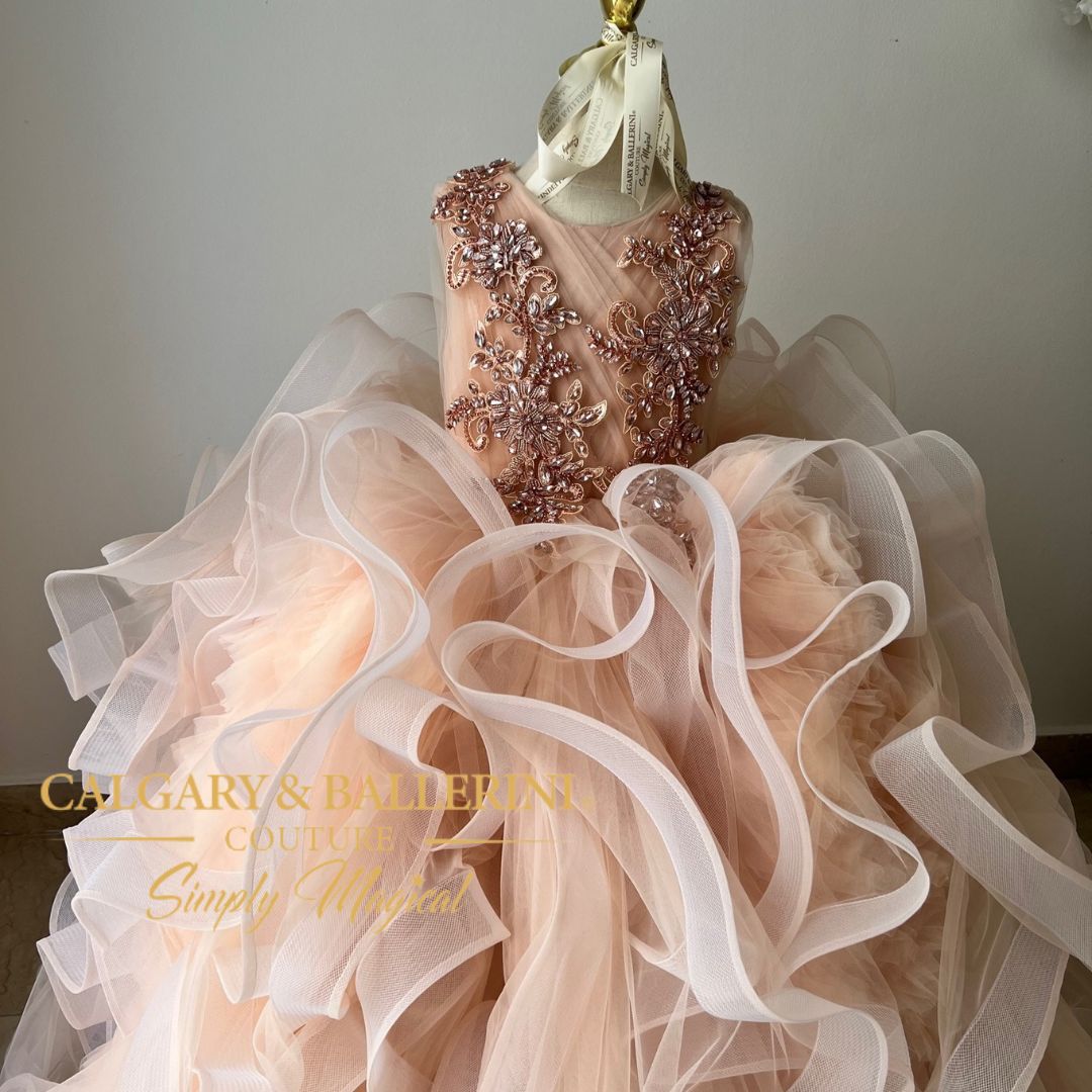 Not only will she look like a dream come true in this beautiful piece, but she'll also stand out with its unique rhinestone peach colored motif on the bodice
