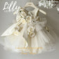 Communion dress with dramatic bow and floral embellishments in ivory