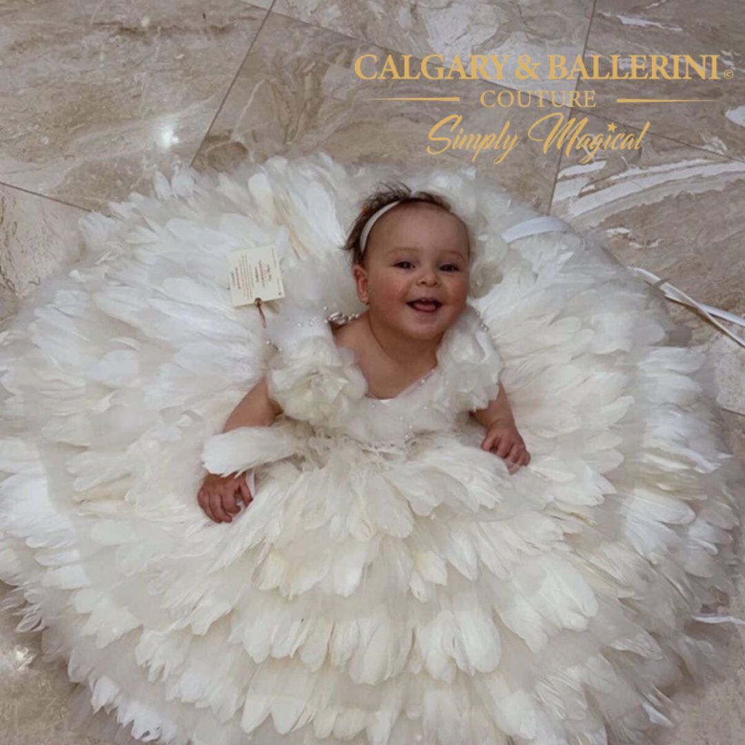 Stunning flower girl dress made with white feathers and satin bodice, perfect for weddings and milestone celebrations.