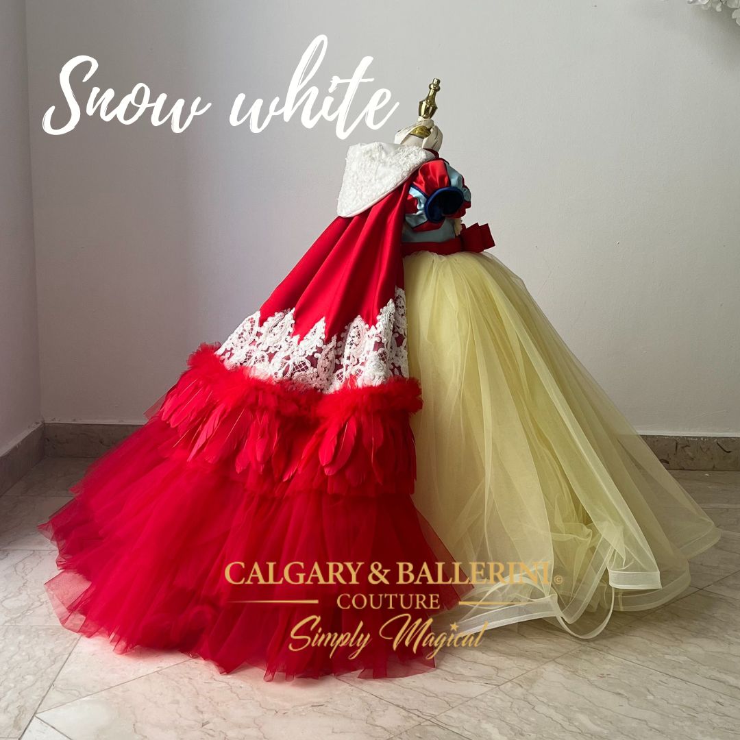 Snow White Costume - Floor Length Tulle Luxury Gown. This luxurious gown is perfect for any formal event! The floor-length tulle skirt and cape with feather details make this dress perfect for a fairytale ball, and the character themed head piece adds the perfect finishing touch